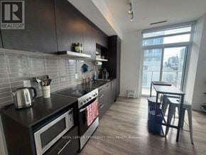 Toronto (Church-Yonge Corridor) condo for rent - A kitchen with black appliances and a black countertop.