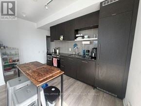 Toronto (Church-Yonge Corridor) condo for rent - A kitchen with a wooden table and black cabinets.