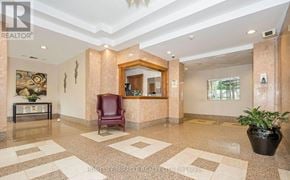 Mississauga (City Centre) condo for rent - A foyer with a red chair and a plant in a black pot.