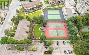 Mississauga (City Centre) condo for rent - A tennis court is surrounded by houses and trees.