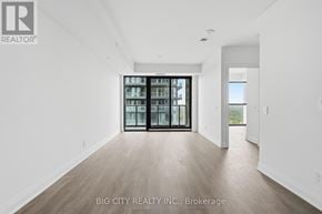 Toronto (Thorncliffe Park) condo for rent - A spacious room with a sliding glass door and wooden flooring.