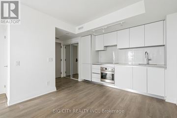 Toronto (Thorncliffe Park) condo for rent - A white kitchen with wooden floors and a sink.
