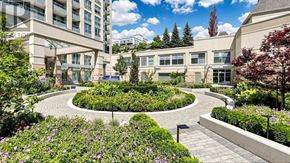 Toronto (Bayview Village) condo for rent - A garden with a circular walkway surrounded by buildings.