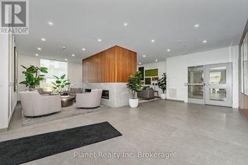 Guelph (Pineridge/Westminster Woods) condo for rent - A modern living room with a black rug and a wooden panelled wall.