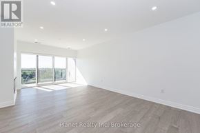 Guelph (Pineridge/Westminster Woods) condo for rent - A large, empty room with a view of trees through the sliding glass doors.