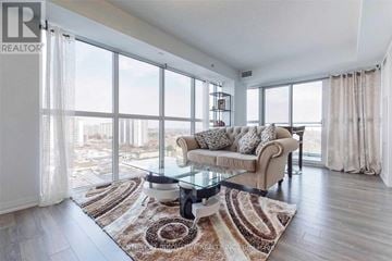 Toronto (Woburn) condo for rent - A living room with a glass table and a couch with a view of the city.
