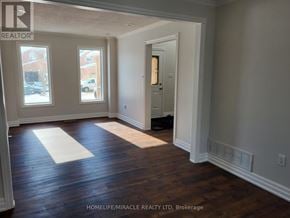 Barrie (Innis-Shore) apartment for rent - A room with wooden floors and white walls, with a doorway leading to another room.