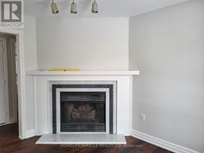 Barrie (Innis-Shore) apartment for rent - A white fireplace in a room with a brokerage logo on the wall.
