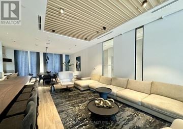 Toronto (Church-Yonge Corridor) condo for rent - A modern living room with a long wooden table and a white sofa.