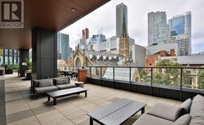 Toronto (Church-Yonge Corridor) condo for rent - A balcony with a table and chairs overlooking a city skyline.