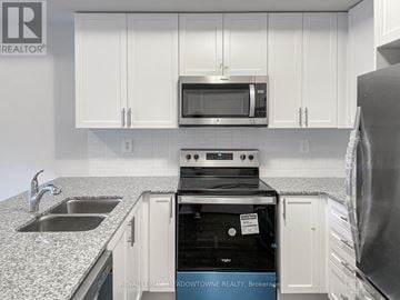 Milton (Cb Cobban) townhouse for rent - A kitchen with white cabinets and a black dishwasher.