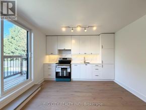 Toronto (Rockcliffe-Smythe) apartment for rent - A well-lit kitchen with white cabinets and a blue appliance.
