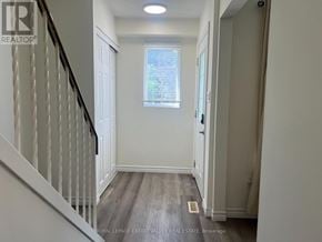 Oshawa (Eastdale) apartment for rent - A hallway with a wooden floor and white walls.
