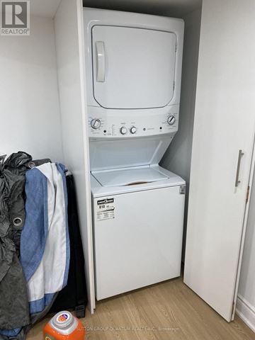Mississauga (Port Credit) multi-family for rent - A small white washing machine sits in a laundry room.