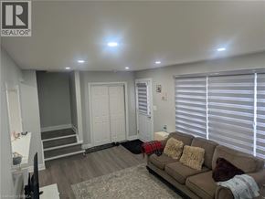 Brantford apartment for rent - A living room with a couch, a television, and a rug.