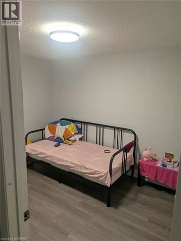 Brantford apartment for rent - A small child's bedroom with a bed and a small table.
