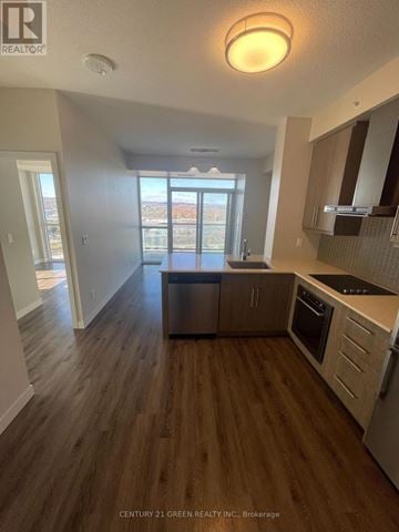 Burlington (Freeman) condo for rent - A kitchen with wooden floors and a large window.