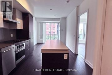 Toronto (Niagara) condo for rent - A kitchen with a stove top oven and a wooden counter top.