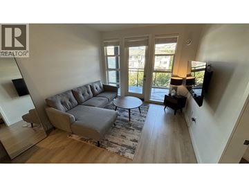 Coquitlam apartment for rent - A living room with a grey couch and a round table.