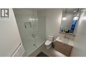 Coquitlam apartment for rent - A bathroom with a glass shower door and a toilet.