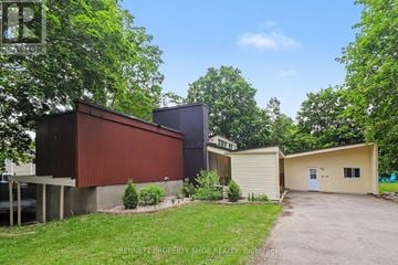 Ottawa house for rent - A property listing image featuring a modern house with a red and brown exterior, surrounded by greenery.