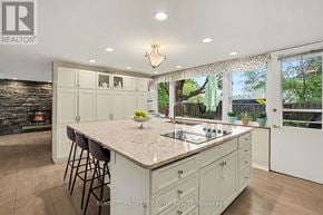 Ottawa house for rent - A kitchen with a large island and a fireplace in the background.
