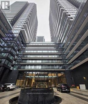 Toronto (Mount Pleasant West) condo for rent - A tall building with a glass facade and a circular entrance with a sign that reads "Homelife/Miracle Realty Ltd."