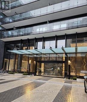 Toronto (Mount Pleasant West) condo for rent - A modern building with a glass entrance and a bicycle parked outside.