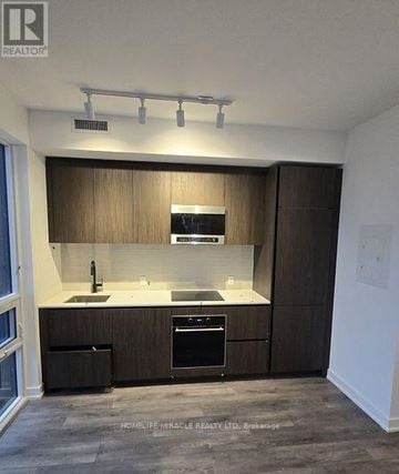 Toronto (Mount Pleasant West) condo for rent - A modern kitchen with wooden cabinets and stainless steel appliances.