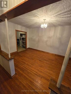 Mississauga (Mineola) apartment for rent - A room with wooden floors and a chandelier hanging from the ceiling.