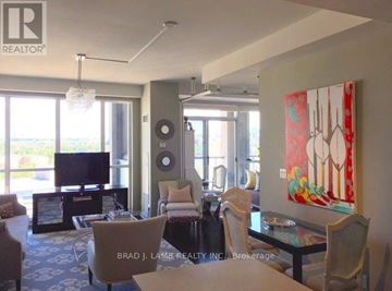 Toronto (Niagara) condo for rent - A living room with a television, chairs, and a painting on the wall.