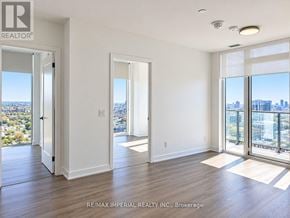 Toronto (Regent Park) condo for rent - A spacious room with a view of the cityscape through large windows.