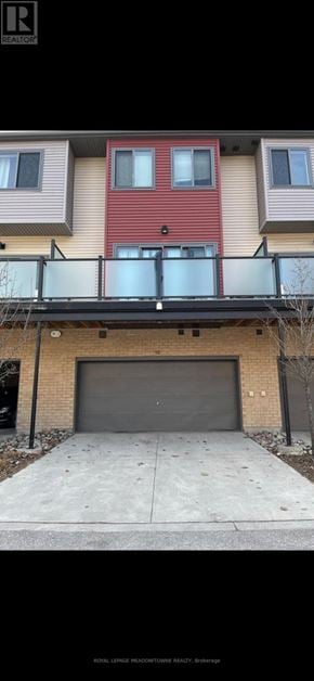 Barrie (Ardagh) townhouse for rent - A red building with a black garage door in front.