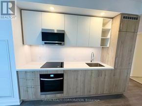Vaughan (Vaughan Corporate Centre) condo for rent - A kitchen with wooden cabinets and a black oven.