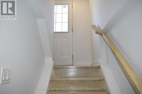 Halton Hills (Ac Acton) apartment for rent - A white door is at the end of a wooden staircase.