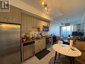 Richmond Hill (Langstaff) condo for rent - A kitchen with wooden cabinets and a stainless steel refrigerator.