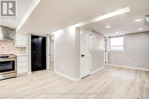 Burlington (Brant) apartment for rent - A modern kitchen with a stone backsplash and a black refrigerator.