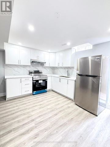Brampton (Credit Valley) apartment for rent - A modern kitchen with white cabinets and a stainless steel refrigerator.