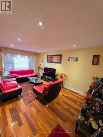 Brampton (Heart Lake West) apartment for rent - A living room with a red couch and a wooden floor.
