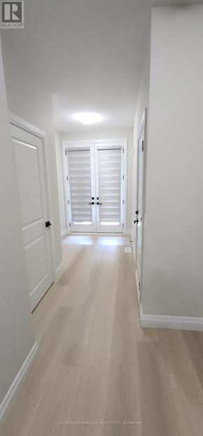 Welland (Lincoln/Crowland) townhouse for rent - A long hallway with white doors and light wood flooring.