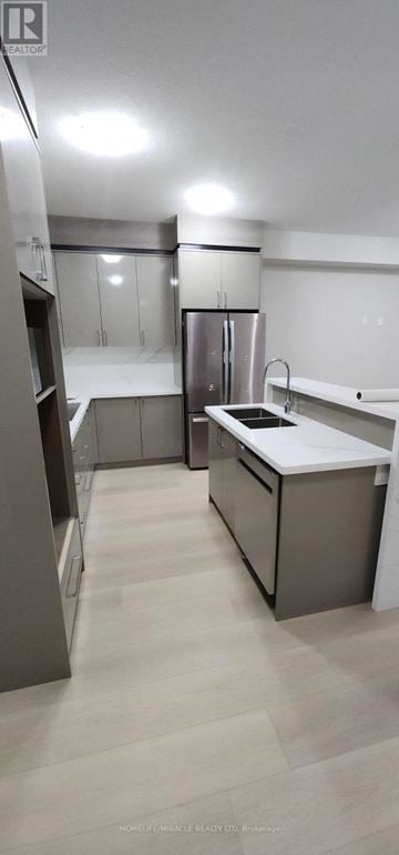 Welland (Lincoln/Crowland) townhouse for rent - A kitchen with a refrigerator, sink, and cabinets.