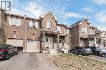 Thorold (Thorold Downtown) townhouse for rent - A large brick house with a driveway and cars parked in front.