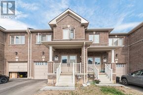 Thorold (Thorold Downtown) townhouse for rent - A large brick house with a garage and a car parked in front.