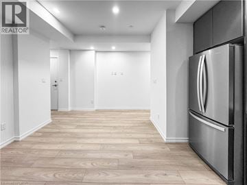Newmarket condo for rent - A modern kitchen with a stainless steel refrigerator and wooden flooring.
