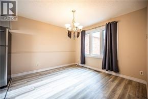 Waterloo townhouse for rent - A room with a chandelier and a window with curtains.