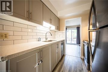 Waterloo townhouse for rent - A kitchen with a refrigerator on the right and a sink in the middle.
