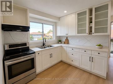 Niagara Falls (Hospital) apartment for rent - A kitchen with white cabinets and a black stove top oven.