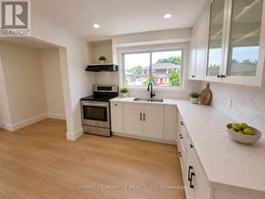 Niagara Falls (Hospital) apartment for rent - A kitchen with white cabinets and a wooden floor.