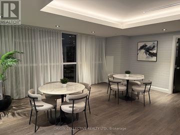 Toronto (Mimico) condo for rent - A dining room with a white table and chairs, a plant, and a framed picture on the wall.
