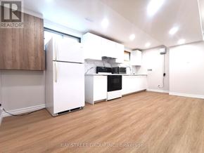Toronto (Pleasant View) apartment for rent - A kitchen with white appliances and wooden cabinets.